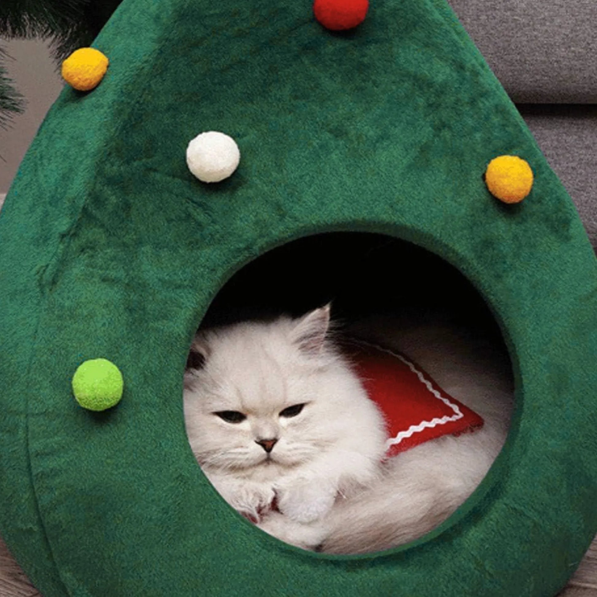 Chat blotti douillettement dans sa grotte panier Noël, ambiance chaleureuse